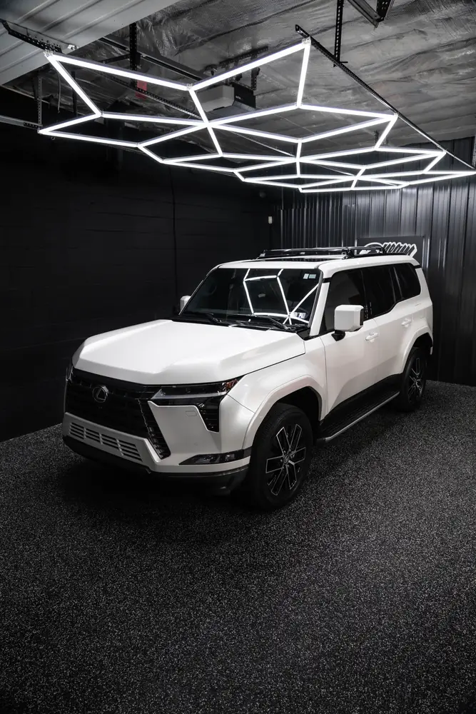 White Lexus GX 550 under the hex lighting in the Dream Auto Garage bay