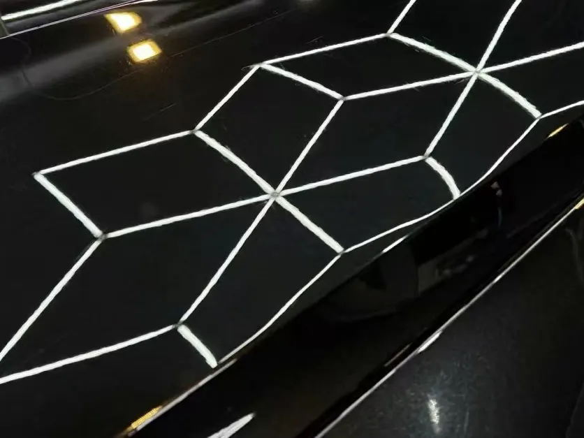 Black paint after multi-stage correction, hex reflections sharp across the panel
