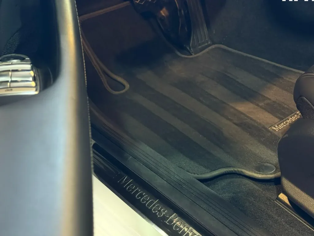 A clean Mercedes door sill and floor mat after a full interior detail