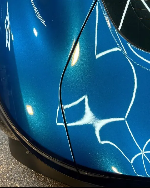 Deep blue paint after multi-stage correction, hex lighting reflected cleanly
